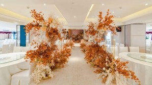 A hotel corridor with white furniture, glass tables, and floral decorations. - Century Chanson Hotel (Mianyang)