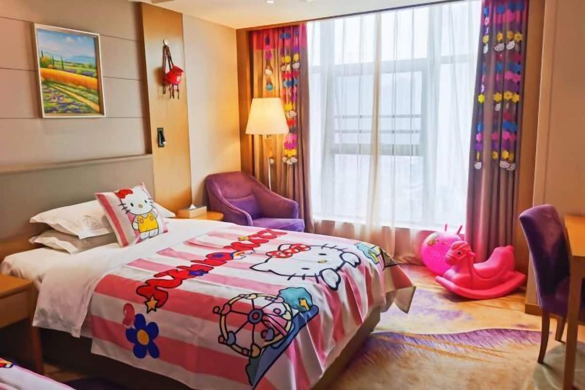 A hotel room with a bed, a chair, a lamp, and a window with curtains.