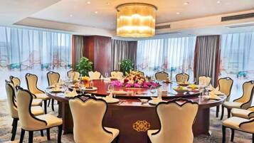 A conference room with a round table, chairs, and a chandelier.