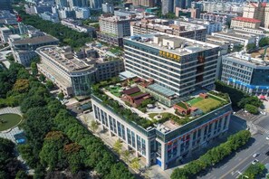 A multi-story building with a rooftop garden and a large sign. - Century Chanson Hotel (Mianyang)