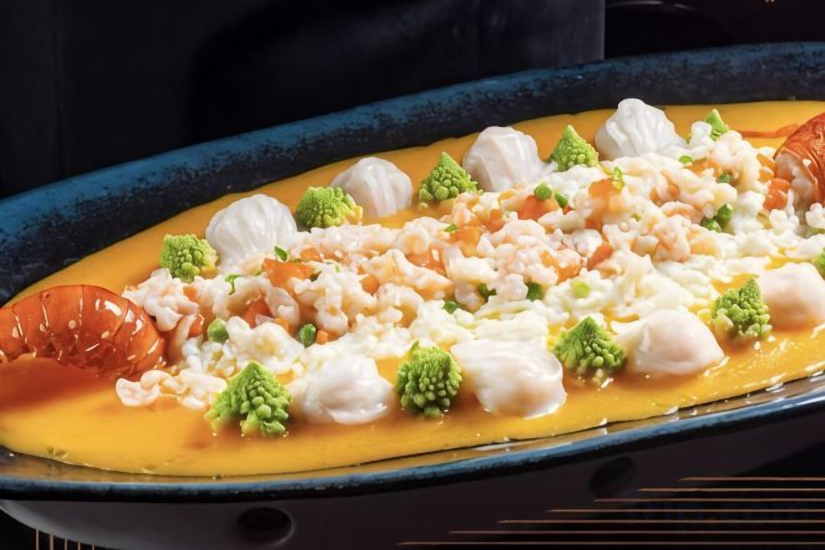 A pan with seafood and broccoli.