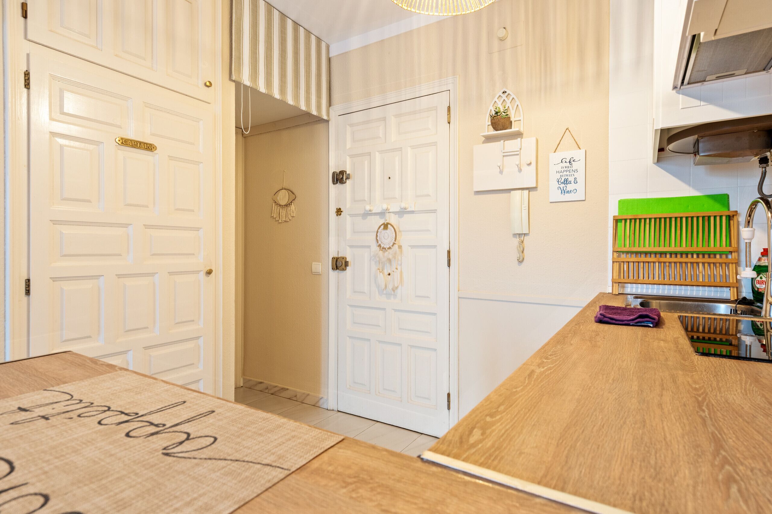 Una cocina con encimera de madera, un lavabo y una tabla de cortar verde.