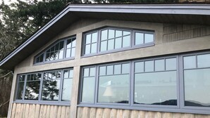 Un bâtiment à deux étages doté de grandes fenêtres et d’une façade en bois.