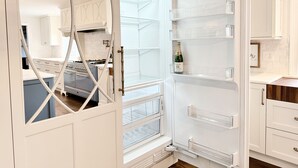 A modern kitchen with white cabinetry, a built-in oven, and a wine fridge. - Spacious Home Near Wallis Sands Beach in Rye NH (Rye)