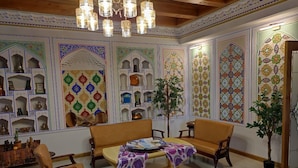 A traditional interior with a sofa set, a coffee table, and decorative shelves. - Nostalgia boutique hotel (Bukhara)
