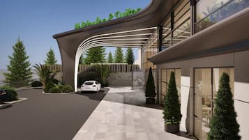 Un bâtiment moderne avec une entrée incurvée, une voiture garée devant et une enseigne au-dessus de l’entrée.