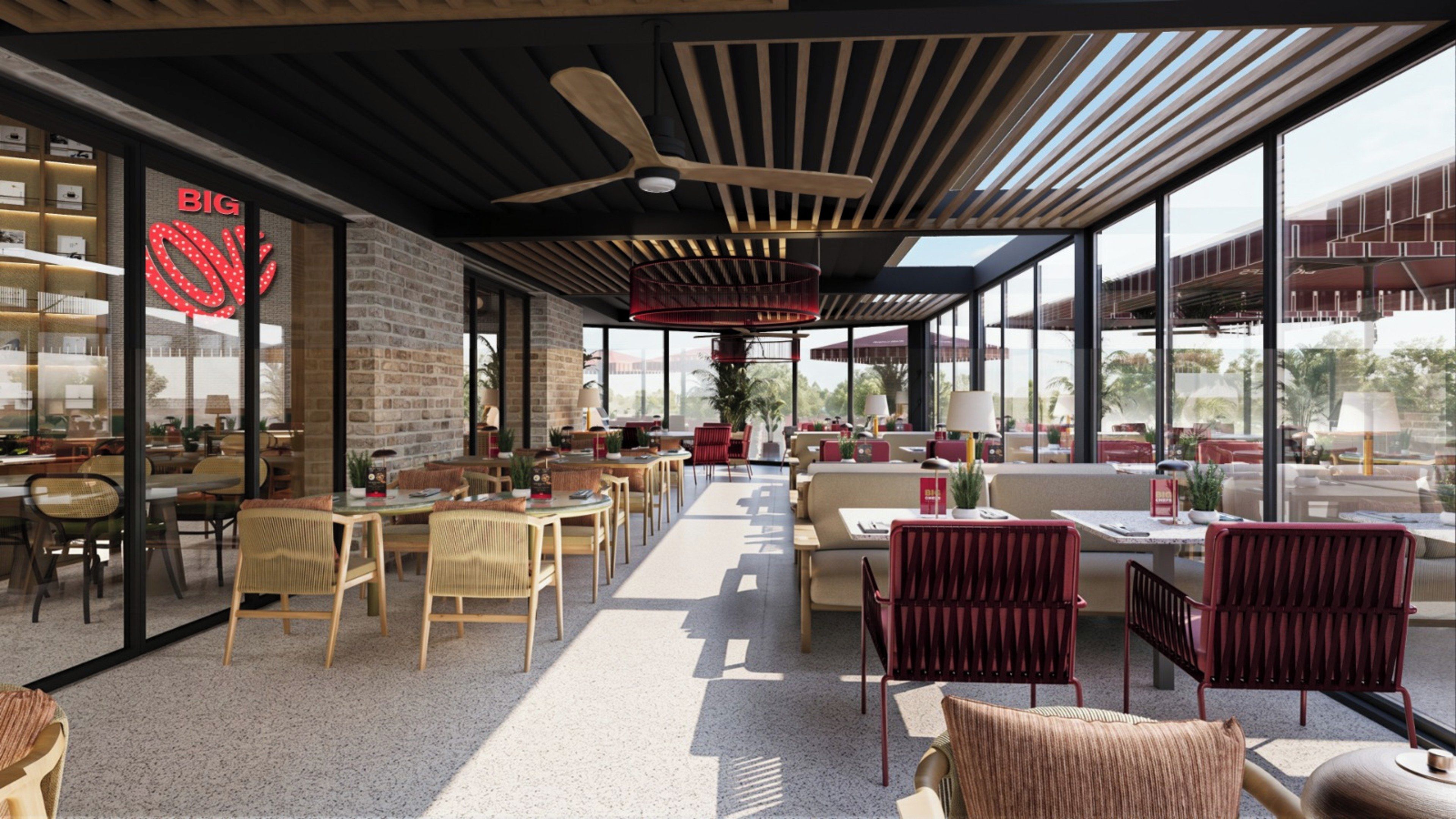 A modern indoor space with a mix of seating areas, including tables and chairs, and a visible store front with a prominent logo.