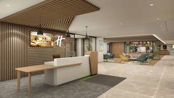 A modern reception area with a wooden reception desk, seating area with colorful chairs, and a large screen displaying content.
