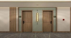 Un conjunto de puertas dobles con los números 202 y 203, una lámpara sobre la puerta central y un detector de incendios en la pared derecha.