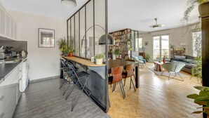 Une cuisine moderne avec un coin repas, une bibliothèque et un canapé.