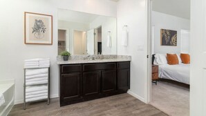A modern bathroom with dark cabinetry, a white vanity, and a large mirror. - *Spacious Family Oasis*Pool Table*Backyard*Garage* (Casa Grande)