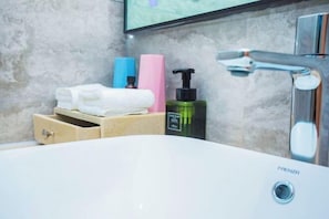 A bathroom with a white sink, a mirror, a towel rack, and toiletries. - He Hotel (Liuyang)