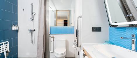 A modern bathroom with a shower, toilet, and sink.