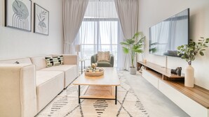 Ein modernes Wohnzimmer mit Sofa, Couchtisch und Fernseher.