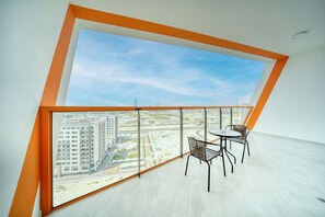 A modern room with a large window, a small table, and two chairs.