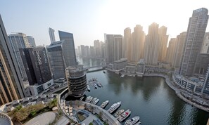 A high-rise urban area with modern architecture, a marina with boats, and a river.