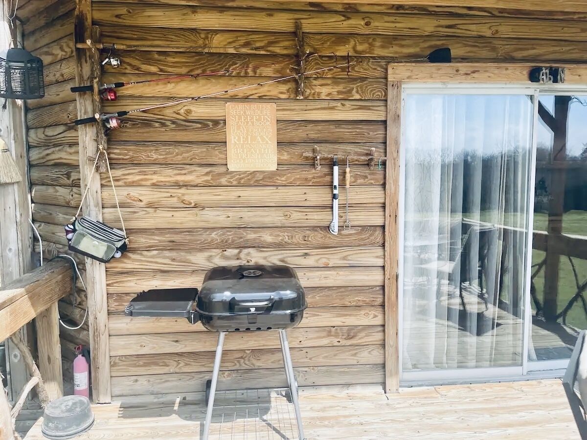 Een houten blokhut met een barbecue, een radio en een brandblusser.