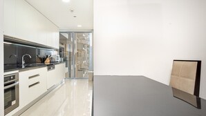 A modern kitchen with stainless steel appliances, a black countertop, and a glass backsplash. - Elegant 1BR in The Address Residences Dubai Marina by Deluxe Holiday Homes (Dubai)