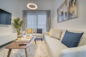 A modern living room with a sofa, coffee table, and a potted plant.