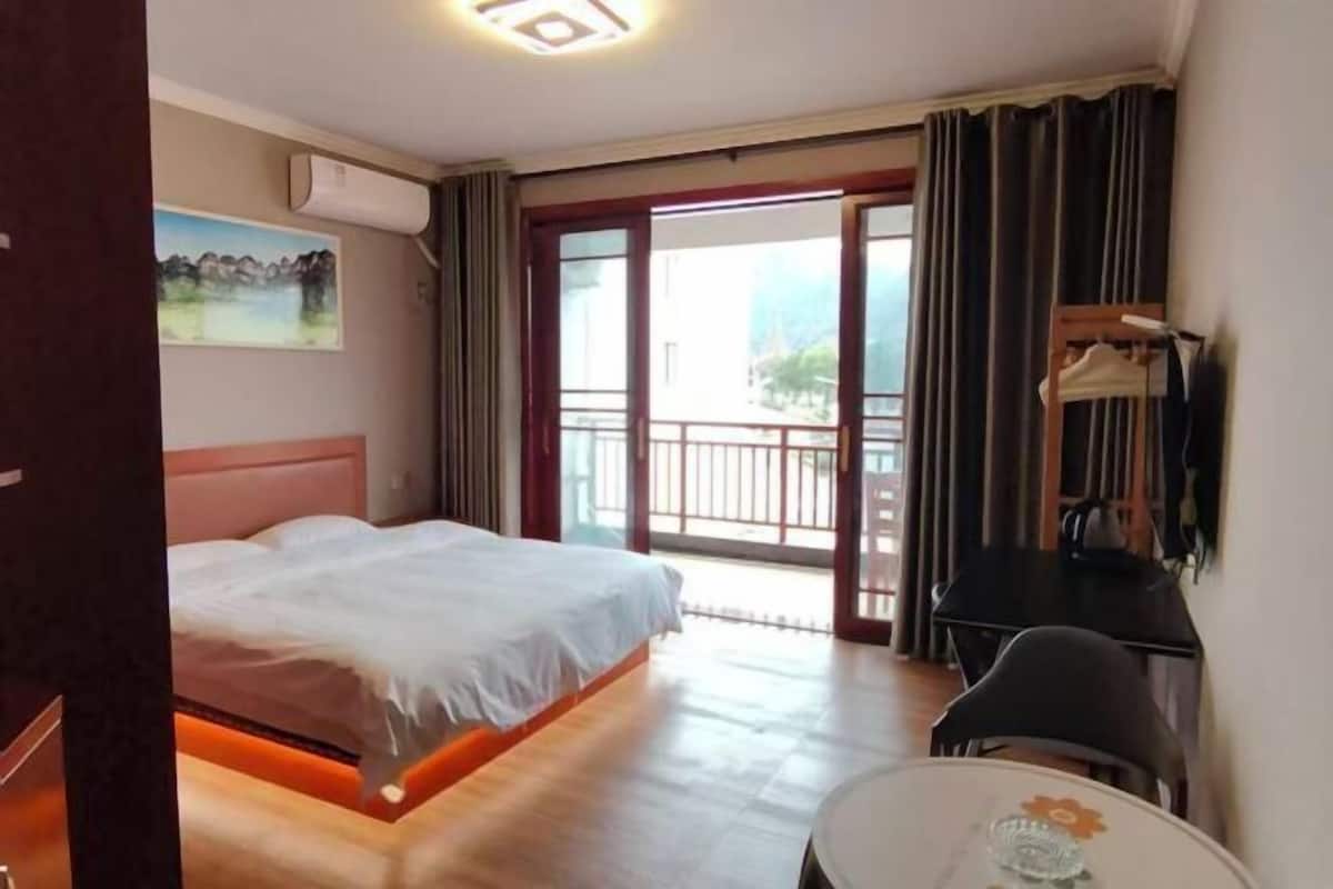 Una habitación de hotel con cama, escritorio y vistas al exterior.