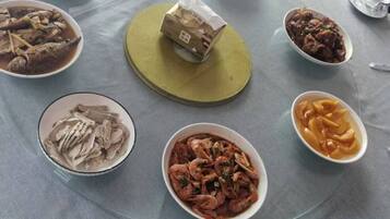 A round table with various dishes, including seafood and a package in the center.