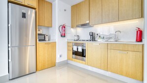 Eine moderne Küche mit Edelstahlgeräten, Holzschränken und einem Feuerlöscher.