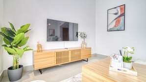 Ein modernes Wohnzimmer mit einem Holzkonsolentisch, einem großen Spiegel und einer Topfpflanze.