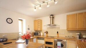 Une cuisine avec des meubles en bois, un four à micro-ondes, une cuisinière et un lave-vaisselle.