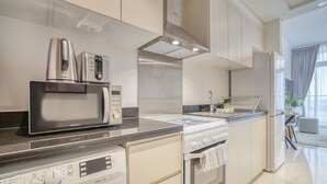 Uma cozinha moderna com micro-ondas, torradeira, chaleira e forno.