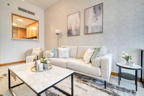 Un salon moderne avec un canapé, une table basse et une table ronde agrémentée d’un vase.