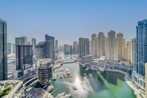 Un quartier urbain caractérisé par de grands immeubles, une architecture moderne, un port de plaisance avec des bateaux et une rivière.