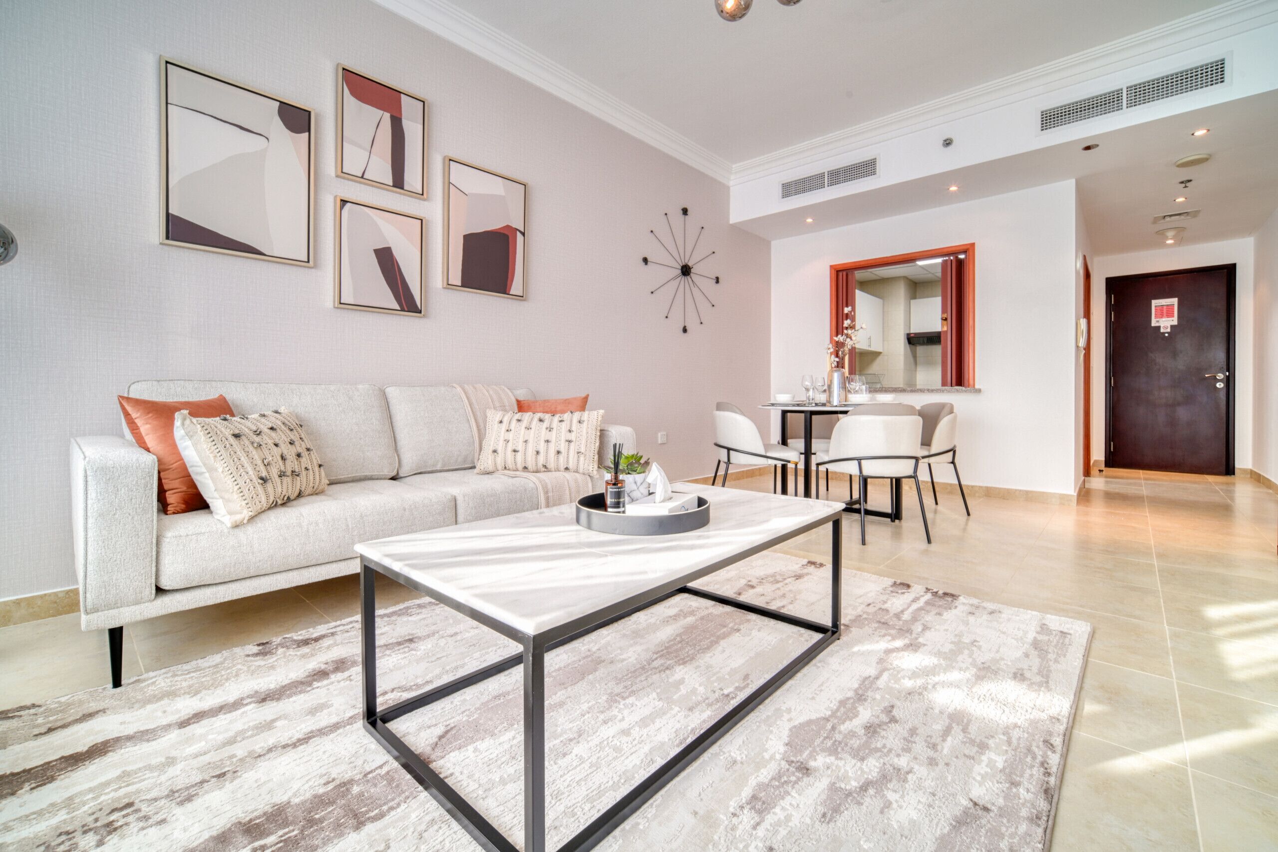 A modern living room with a sofa, coffee table, and dining area.
