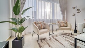 A modern living room with two sofas, a coffee table, a potted plant, and a floor lamp.