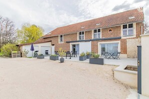 A two-story brick building with a tiled roof, outdoor seating area, and potted plants. - la Grange - Pontoux - Gîte (PONTOUX)