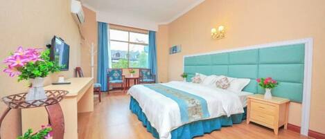 A bedroom with a bed, bedside table, desk, chair, and a window.