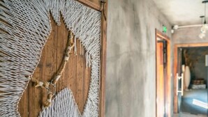 Un mur en bois orné d’un motif tissé original et d’une découpe circulaire.