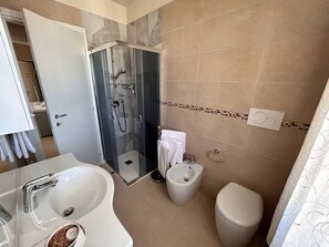 Een douche, een haardroger, een bidet, handdoeken