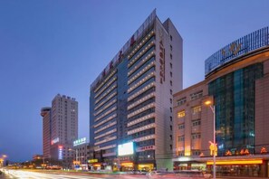 A multi-story hotel with a modern facade, large windows, and a prominent signage.