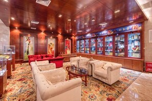 A hotel lobby with a red sofa, white armchairs, a coffee table, and a display of refrigerated beverages. - Wuzhou International Hotel (Shenmu)
