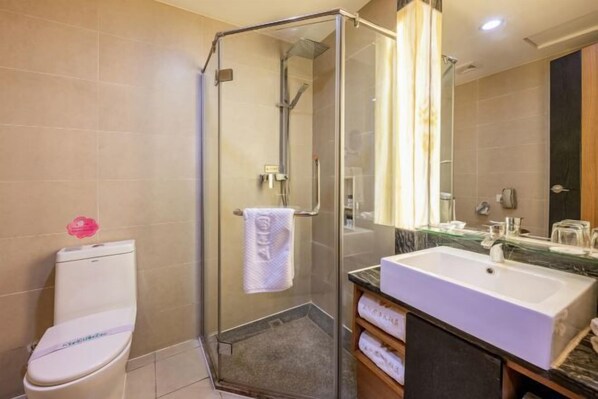 Un baño moderno con ducha de vidrio, un lavabo blanco y un espejo grande.