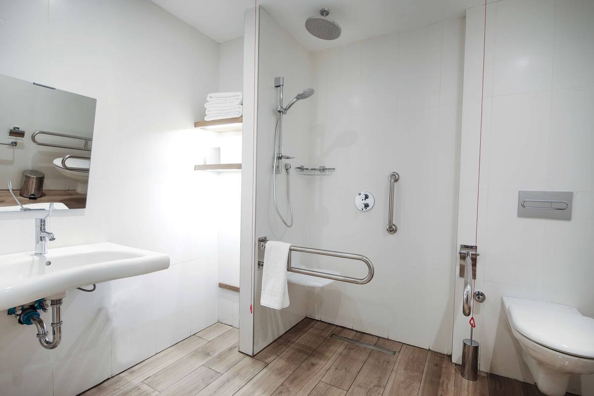 Ein modernes Badezimmer mit Waschbecken, Toilette und Dusche.
