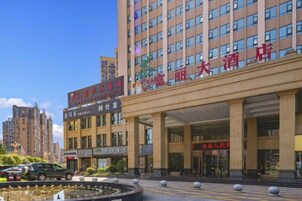 Un hotel con una entrada amplia, varios pisos y un letrero que indica que es un hotel.