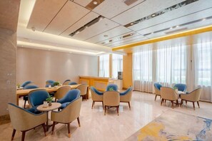 Une chambre d’hôtel moderne dotée d’un coin repas, d’une cuisine et de grandes fenêtres.
