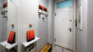 A bathroom with white brick walls, a white door, and a marble floor. There are two sinks with mirrors and artwork above them. - The little house on franciosa street (Siena)