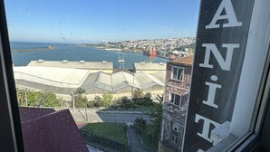 A view from a window overlooking a coastal area with a building labeled "GANT". - Ganita Life Hotel (Trabzon)