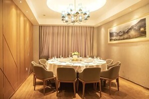 Une salle à manger avec une table ronde, six chaises et un lustre.