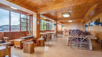Un interior espacioso de madera con ventanas amplias, muebles de madera y vistas al exterior.