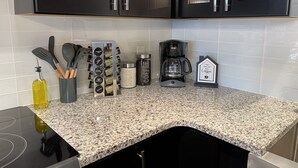 A kitchen with granite countertops, black cabinets, and stainless steel appliances. - Golf Getaway with Golf Cart on Grand Lake in Shangri-La (Afton)