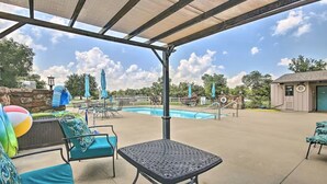 An outdoor pool area with lounge chairs and umbrellas. - Golf Getaway with Golf Cart on Grand Lake in Shangri-La (Afton)