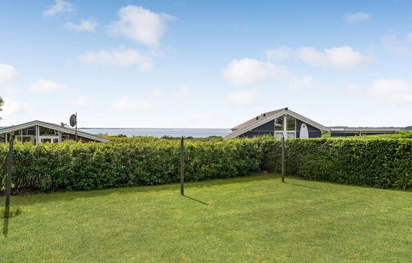 A coastal property with a grassy lawn, a hedge, and a view of the sea. - 2 bedroom awesome home in Faaborg (Faaborg)